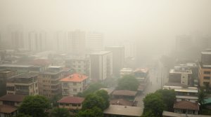 Hanoi, Vietnam, veiled in smog, depicted in natural earth tones, using browns, beiges, and muted colors